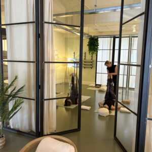 Vrouw in restorative yogahouding ondersteund met kussens in Her Space Bussum